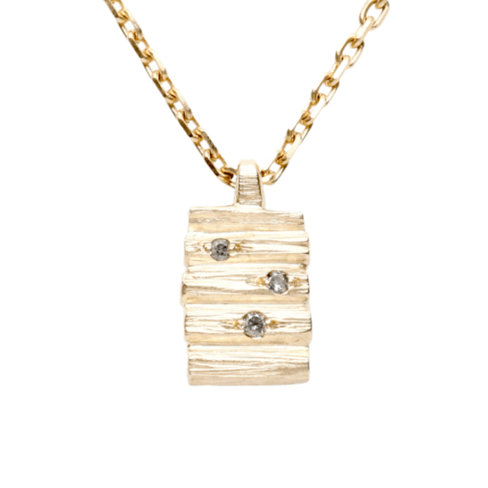Henge pendant featuring stacked lithic columns with salt and pepper diamonds, set on a yellow gold chain.
