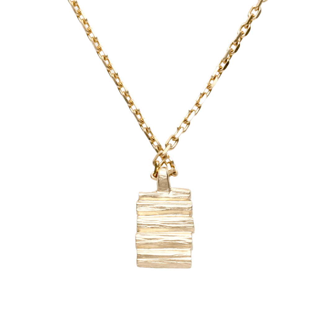 Henge pendant necklace featuring stacked lithic columns and 9 carat yellow gold chain.